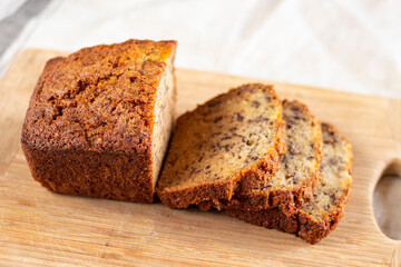 Sliced loaf of banana bread cupcake with poppy seeds on cooling wrack