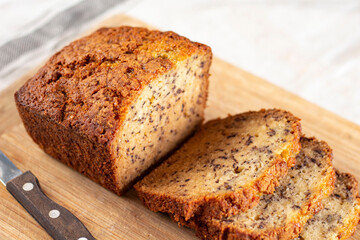 Sliced loaf of banana bread cupcake with poppy seeds on cooling wrack