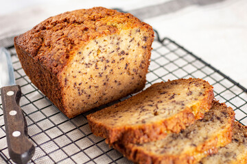 Sliced loaf of banana bread cupcake with poppy seeds on cooling wrack