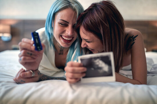 Happy lesbian couple sharing a pregnancy test results