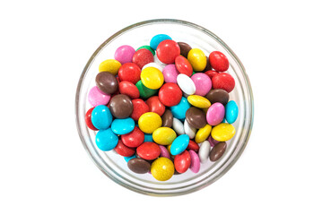 round colored candies in a glass plate on a white background.