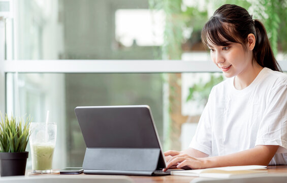 Young pertty woman using computer while stay at home, work from home concept.
