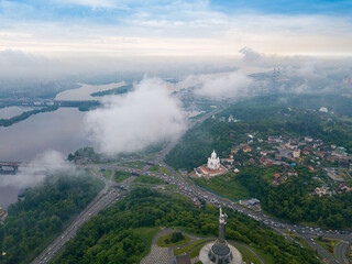 Fototapeta premium High view of the Dnieper River in Kiev through the clouds. Spring cloudy morning. Aerial high view.