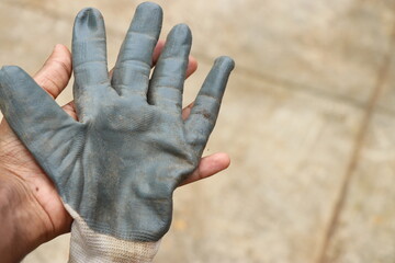 Working gloves held in hand after garden works with clean hands underneath. Protective gloves to...