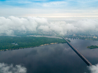 High view of the Dnieper River in Kiev through the clouds. Spring cloudy morning. Aerial high view.