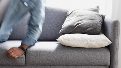 Exhausted young  Indian man falling down on couch at home, male feels tired and sleepy after a long day at work, need rest concept