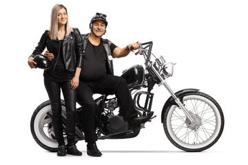 Obraz na płótnie Canvas Mature biker and a young woman in leather clothes standing next to his chopper