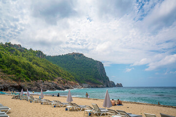 Fototapeta na wymiar Cleopatra beach on sea coast with green rocks in Alanya 