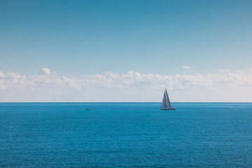 Sea and sailing wind boat. Sailboat over blue waves and sunny sky