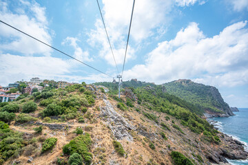 Fototapeta na wymiar Having a 900 meter line length, Alanya Teleferik has become a symbol of Alanya and offering fascinating journey between Cleopatra beach and Alanya castle, 
