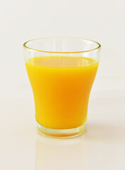 A glass of cold orange juice against white background