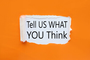 Tell Us What You Think. text on white paper near torn orange paper
