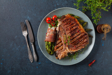 Grilled, medium-baked t-bone beef steak. Served with asparagus.