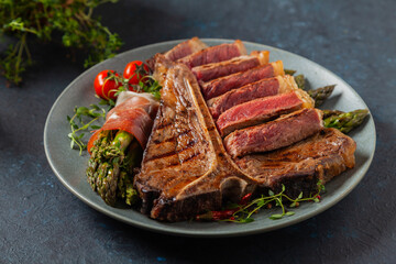 Grilled, medium-baked t-bone beef steak. Served with asparagus.