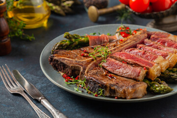 Grilled, medium-baked t-bone beef steak. Served with asparagus.
