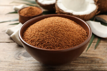 Natural coconut sugar in bowl on wooden table