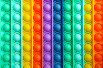 Trendy popular silicone colorful anti stress pop it toy . Close up. Someone push sensory popit. Trendy hype theme from tik tok - obrazy, fototapety, plakaty