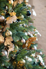 Christmas decorations with a Christmas tree and garlands for the living room in gold tones, vertical photo