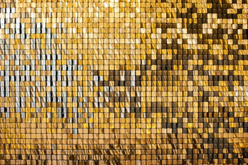 Gold glittering squares on the wall, interior decor, background.