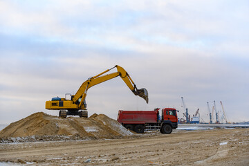 Fototapeta na wymiar Yellow excavator working on construction site. The road construction.
