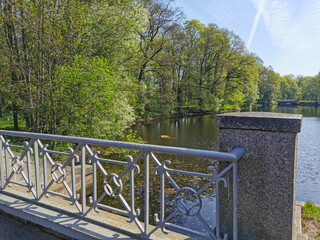 Figure fence of the bridge over the canal on a sunny spring day in the park on Elagin Island in St. Petersburg.