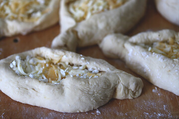 Raw khachapuri on a wooden board. Cooking homemade khachapuri.