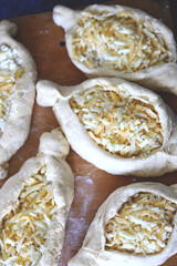 Raw khachapuri on a wooden board. Cooking homemade khachapuri.