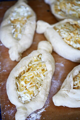 Raw khachapuri on a wooden board. Cooking homemade khachapuri.