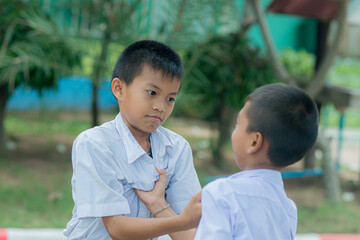 Two Asian schoolboys facing each other getting bullied Children fighting with classmates in the...