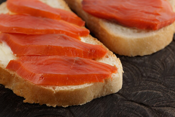 Open-face sandwiches with smoked trout on wooden board