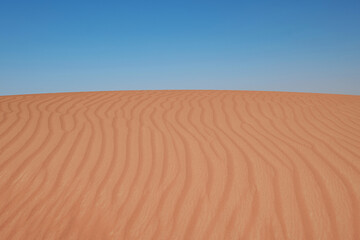 Sunset over the sand dunes in the desert.