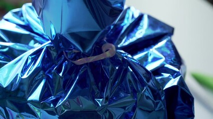 european girl packs a gift in a blue shiny package