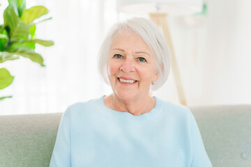 portrait of elderly woman sit on the sofa at home
