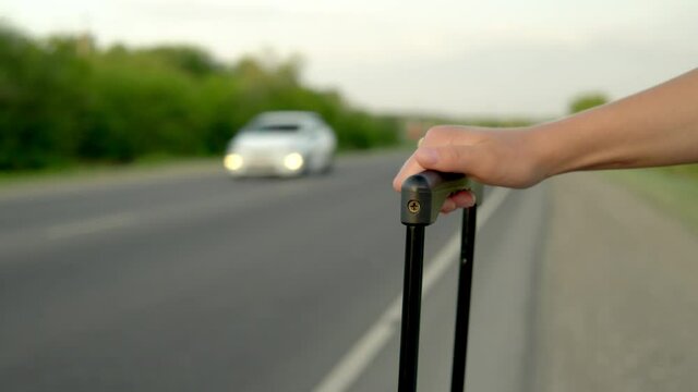 Close-up of a woman holding a handle in a suitcase