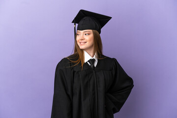 Young university graduate over isolated purple background looking to the side and smiling