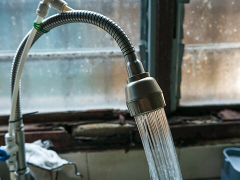 An image of high pressure water coming out of the sink pipe. Selective focus image.