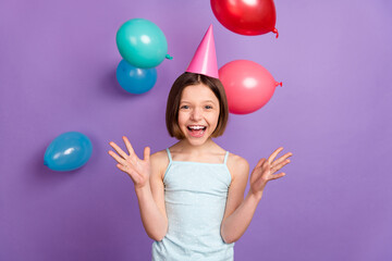 Fototapeta na wymiar Photo of cheerful happy positive small girl fall air balloons smile wear cone hat isolated on violet color background