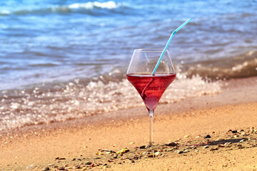 Wine glass with a cocktail by the sea.