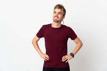 Young handsome man isolated on white background posing with arms at hip and smiling