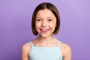 Photo of cheerful young happy small girl smile good mood beaming isolated on purple color background