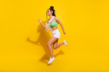 Fototapeta na wymiar Full length photo of brunette afro american young woman jump up run empty space isolated on yellow color background