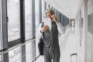 Senior businessman with travel suitcase in airport