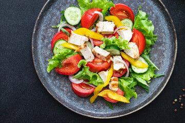 fresh chicken salad and vegetables tomato, cucumber, pepper organic wholesome dish on the table healthy food meal snack copy space food background rustic. top view keto or paleo diet veggie