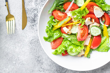 fresh chicken salad and vegetables tomato, cucumber, pepper organic wholesome dish on the table healthy food meal snack copy space food background rustic. top view keto or paleo diet veggie