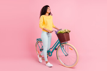 Full length body size view of attractive cheerful girl walking bike spending day time isolated over pastel pink color background