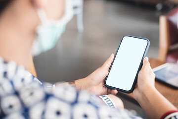 Mobile phones or smartphones are being used by smart Asian business women..Used to find information, check e-mail, study online, work on the Internet..It is a work from home concept.