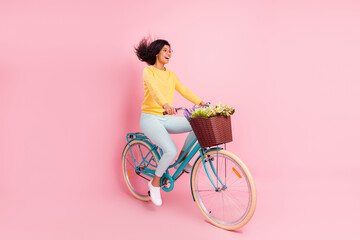 Portrait of pretty cheerful girl riding bike having fun fast speed motion isolated over pastel pink...