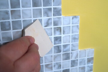Image of the process of filling the seams of tiled mosaic.