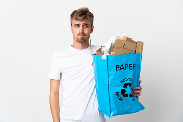 Young blonde man holding a recycling bag full of paper to recycle isolated on white background...