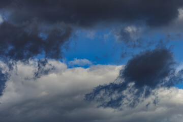 Obraz premium Dark storm clouds on a bright blue sky. Sky patterns background 2021.